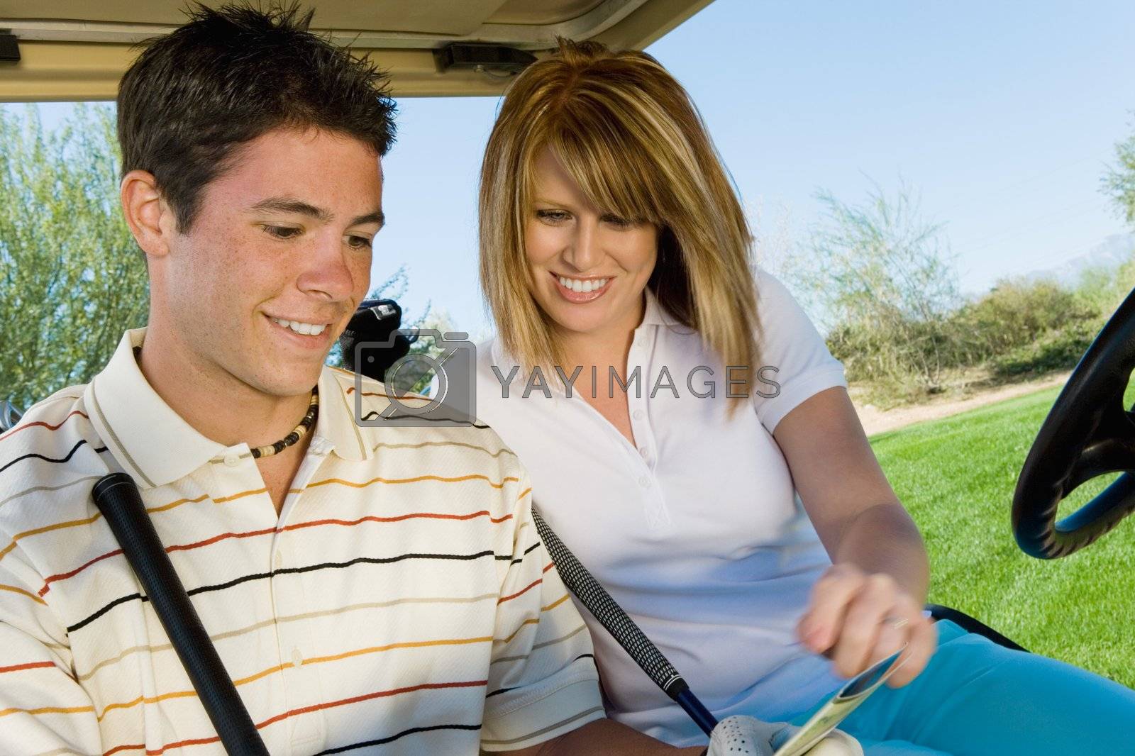 Royalty free image of Golfers Looking at Score Card by moodboard
