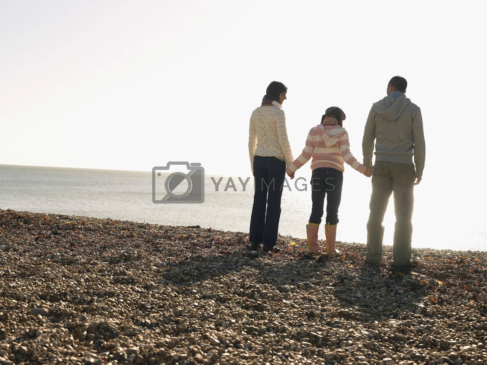 Royalty free image of Married Couple Holding Hands with Their Daughter by moodboard