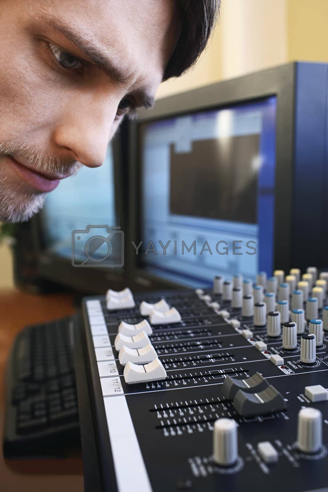 Royalty free image of Man Looking at Levels on Mixing Board by moodboard