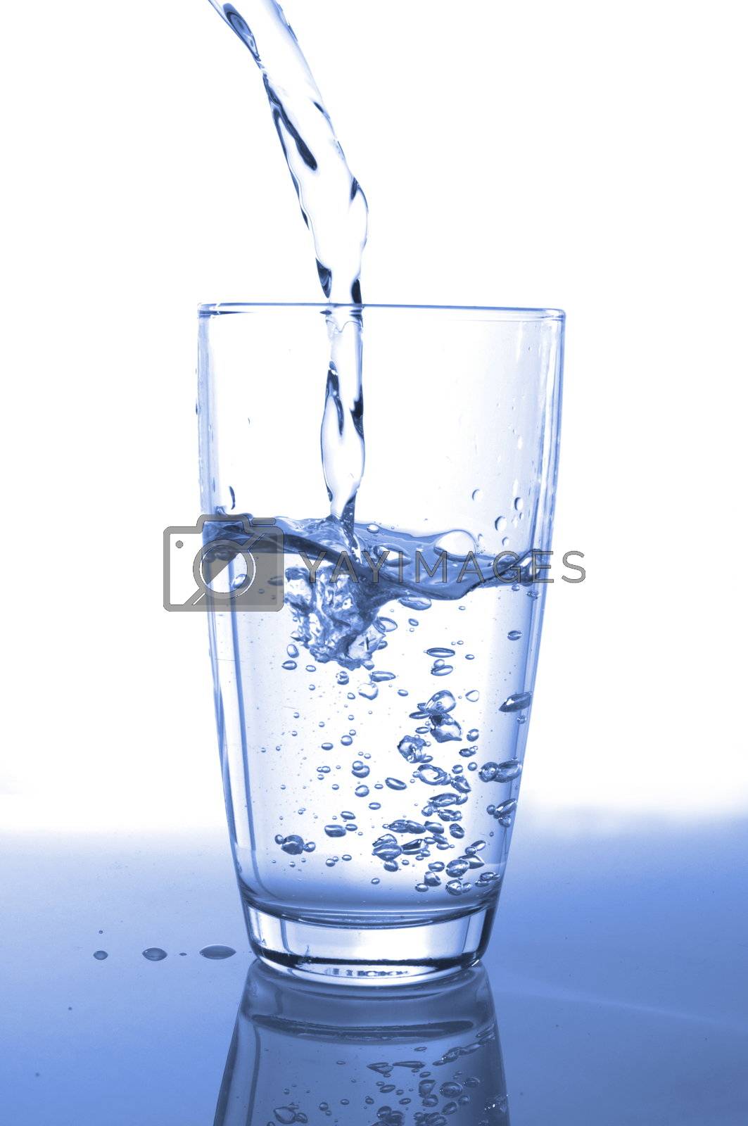 pouring fresh water in a glass on white                                    