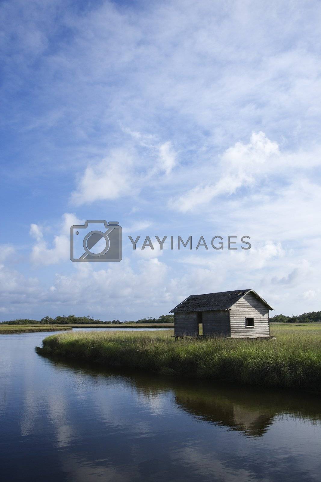 Royalty free image of Weathered building on marshy creek. by iofoto