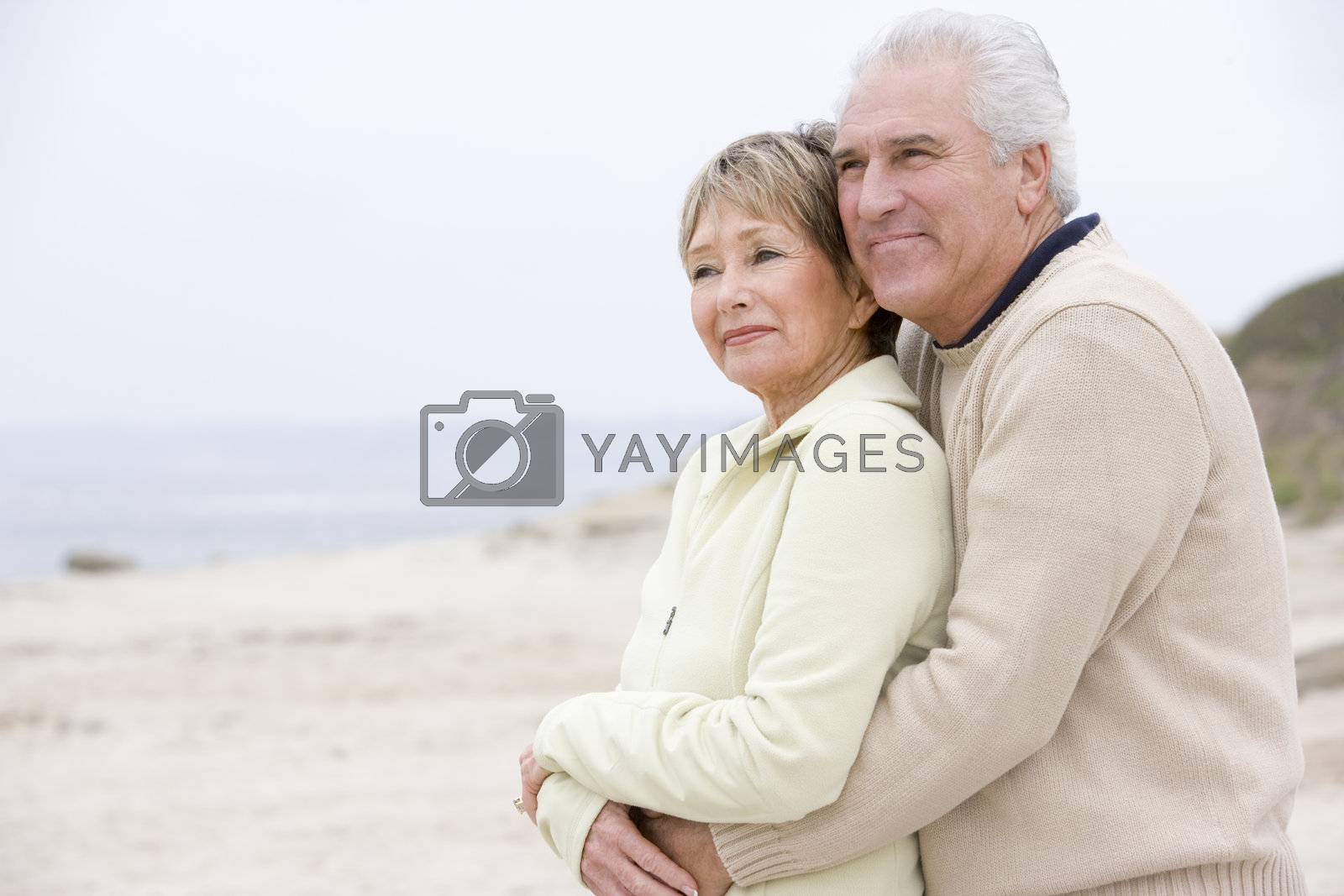 Royalty free image of Couple at the beach embracing and smiling by MonkeyBusiness