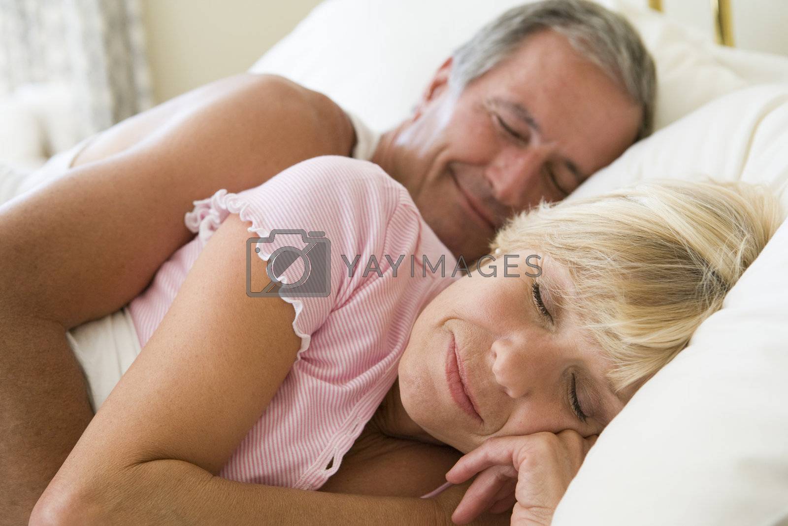 Royalty free image of Couple lying in bed sleeping by MonkeyBusiness