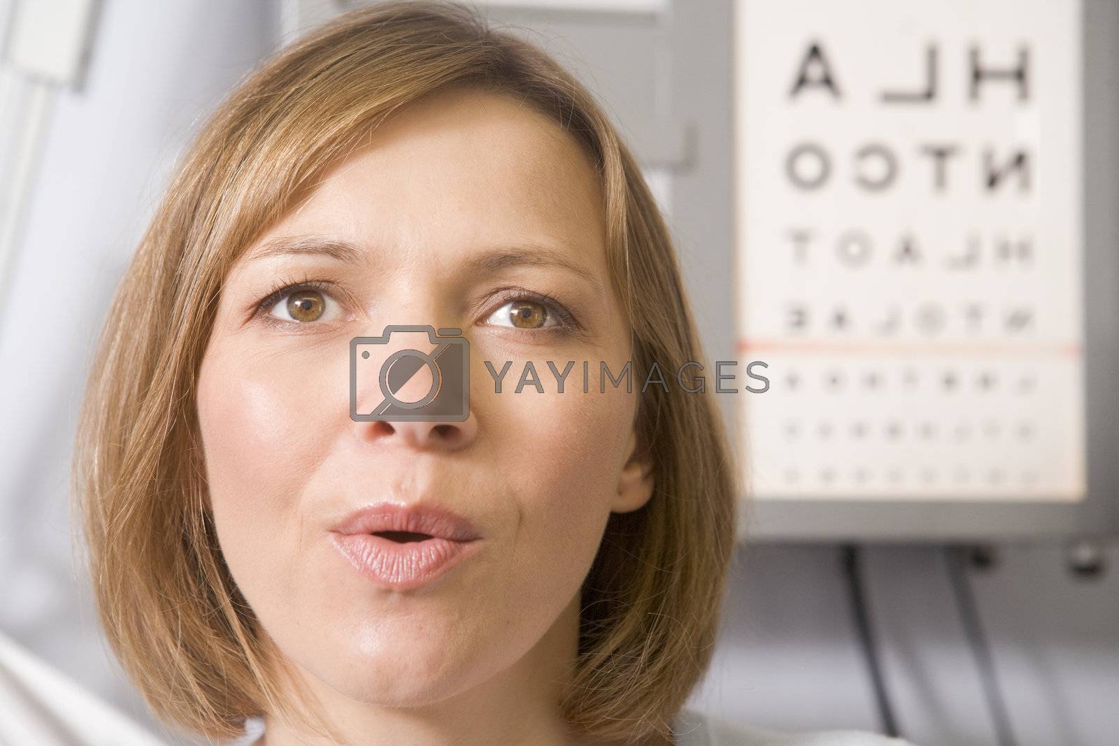 Royalty free image of Woman in optometrist's exam room taking deep breath by MonkeyBusiness