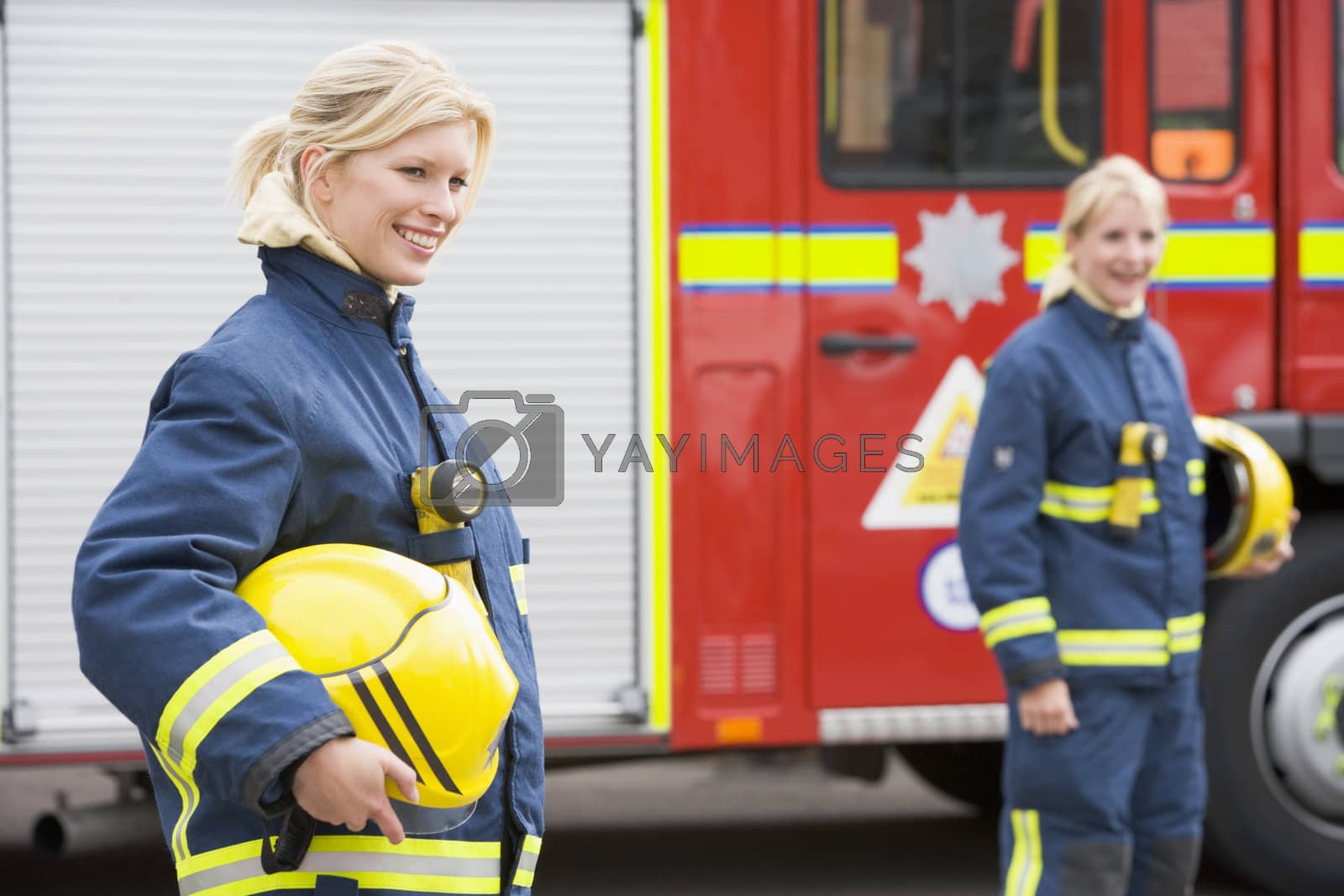 Royalty free image of Two female firefighters by a fire engine by MonkeyBusiness