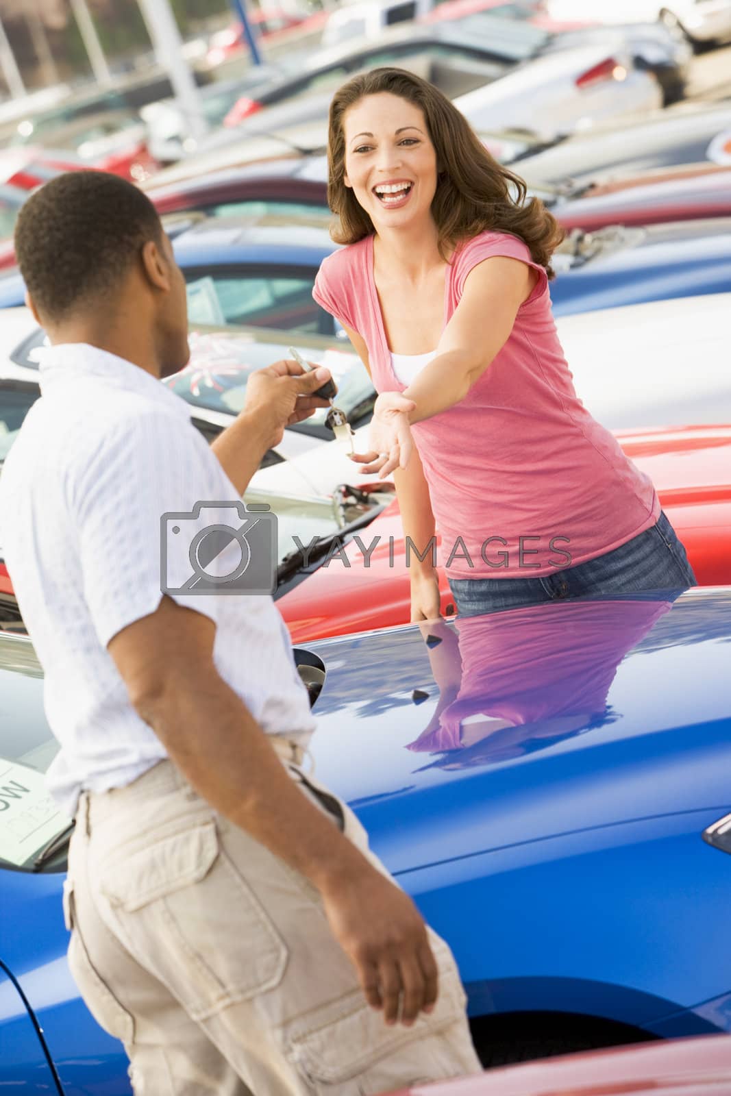 Royalty free image of Woman picking up keys to new car by MonkeyBusiness