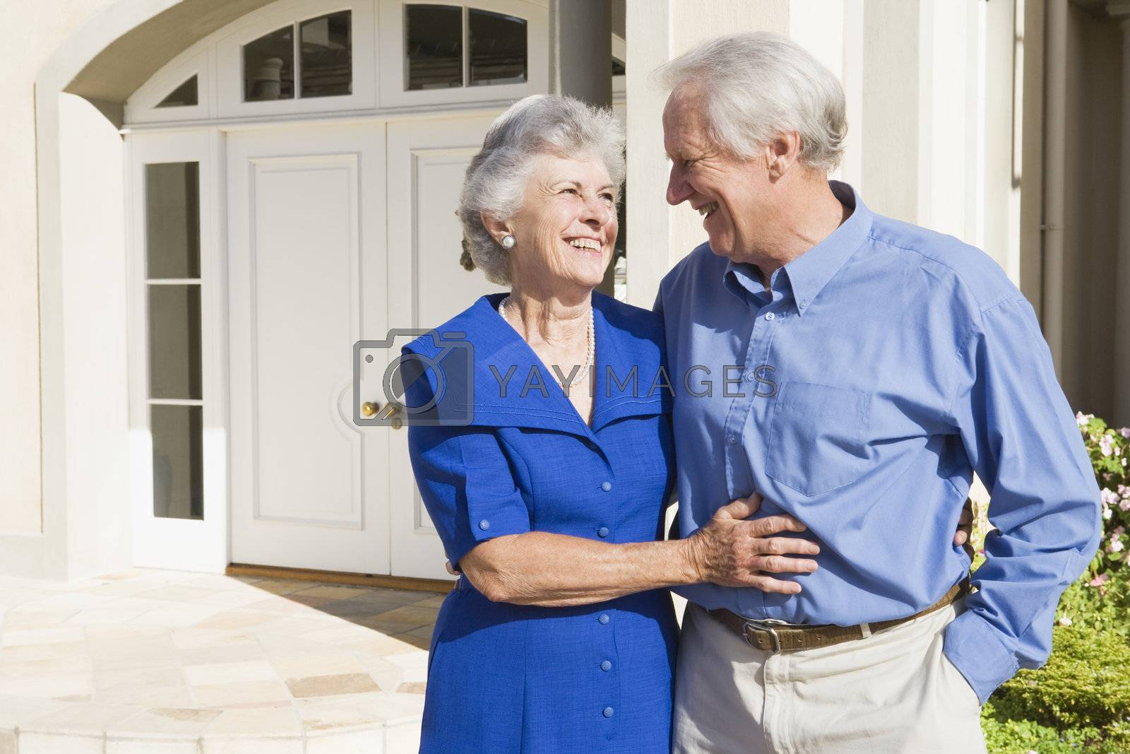 Royalty free image of Senior couple standing outside house by MonkeyBusiness