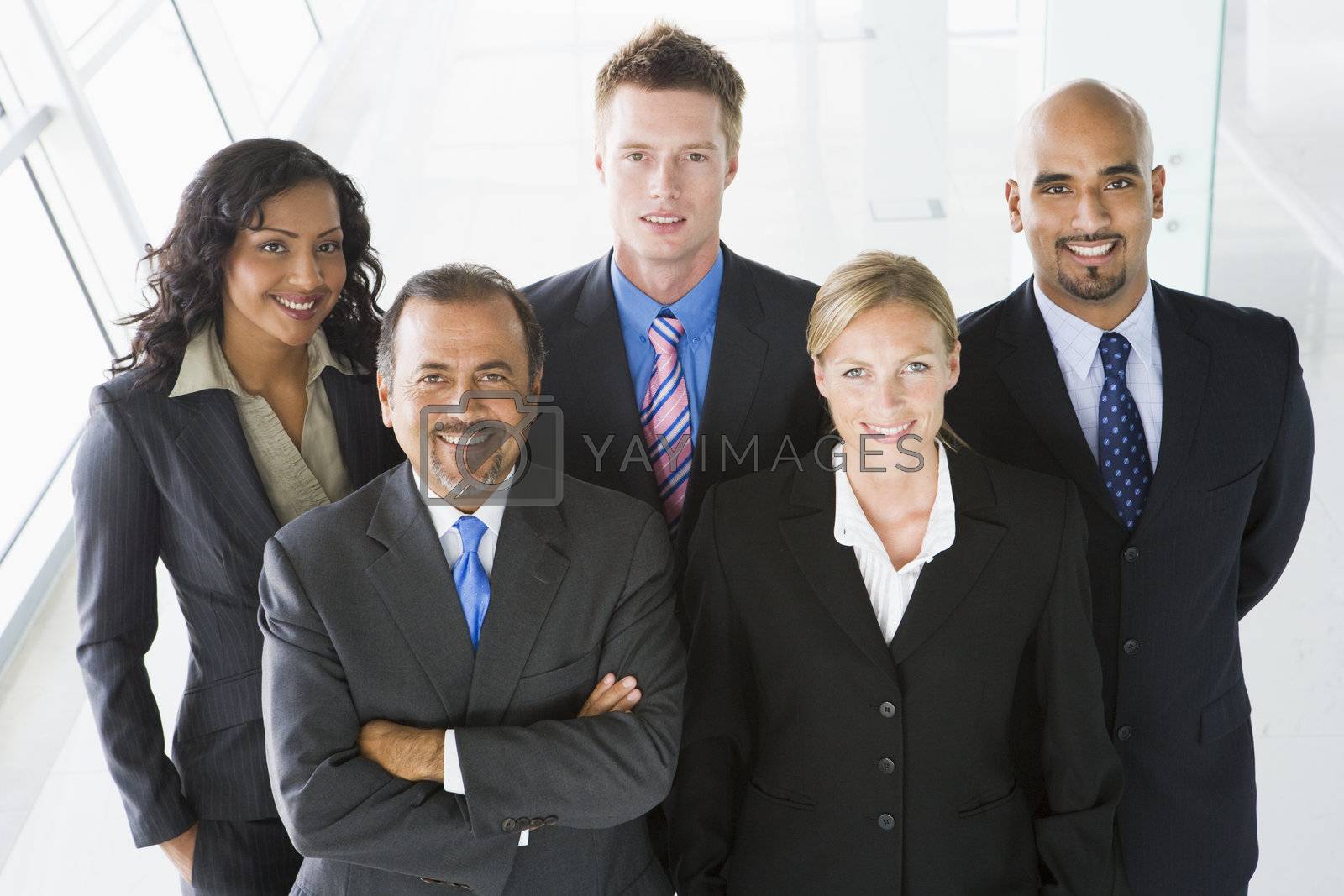 Royalty free image of Group of co-workers standing in office space smiling (high key/depth of field) by MonkeyBusiness