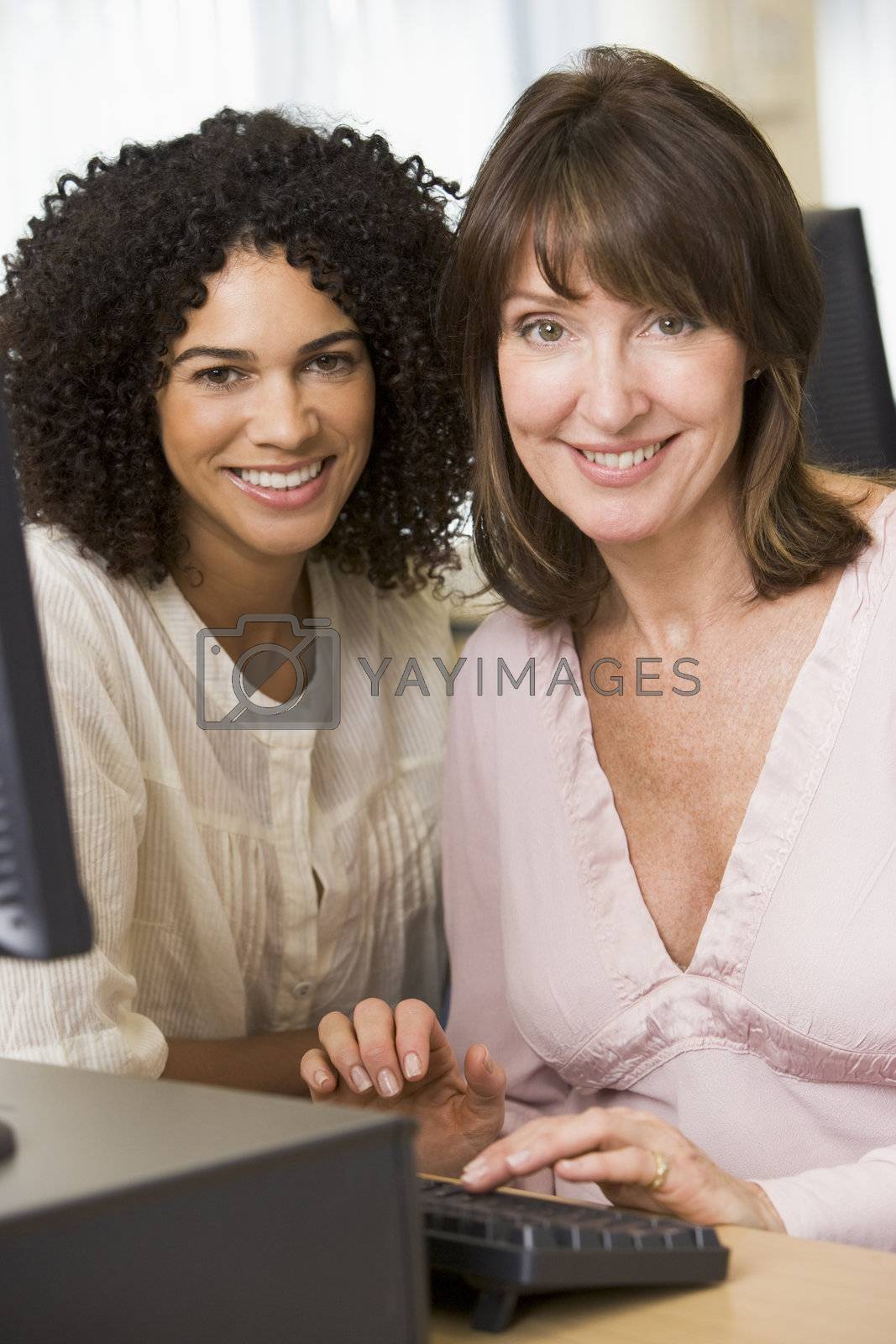 Royalty free image of Two women at a computer terminal typing (high key) by MonkeyBusiness