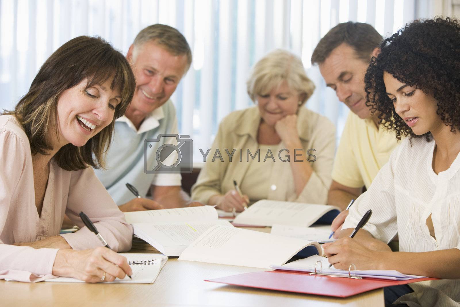 Royalty free image of Five adult students studying at table (depth of field) by MonkeyBusiness