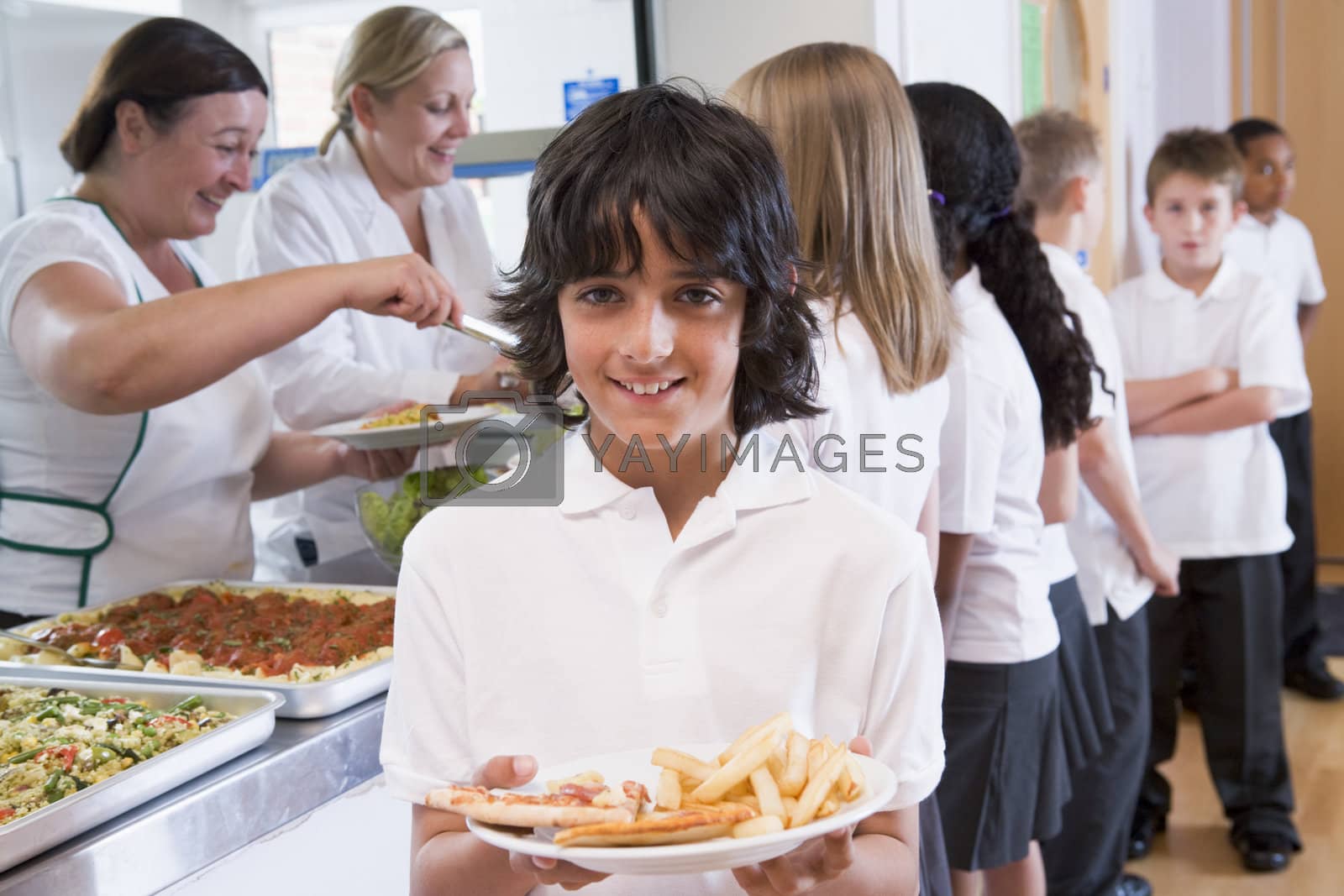 Royalty free image of Students in cafeteria line with one holding his healthy meal and looking at camera (depth of field) by MonkeyBusiness