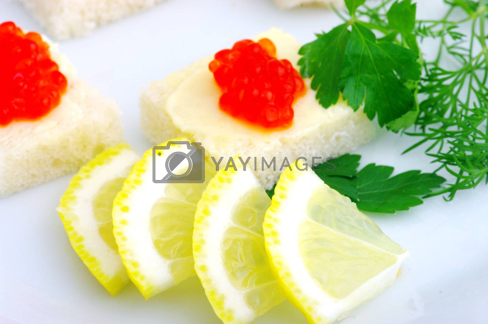 Royalty free image of Sandwiches with red caviar and greens on a white plate  by dolnikow