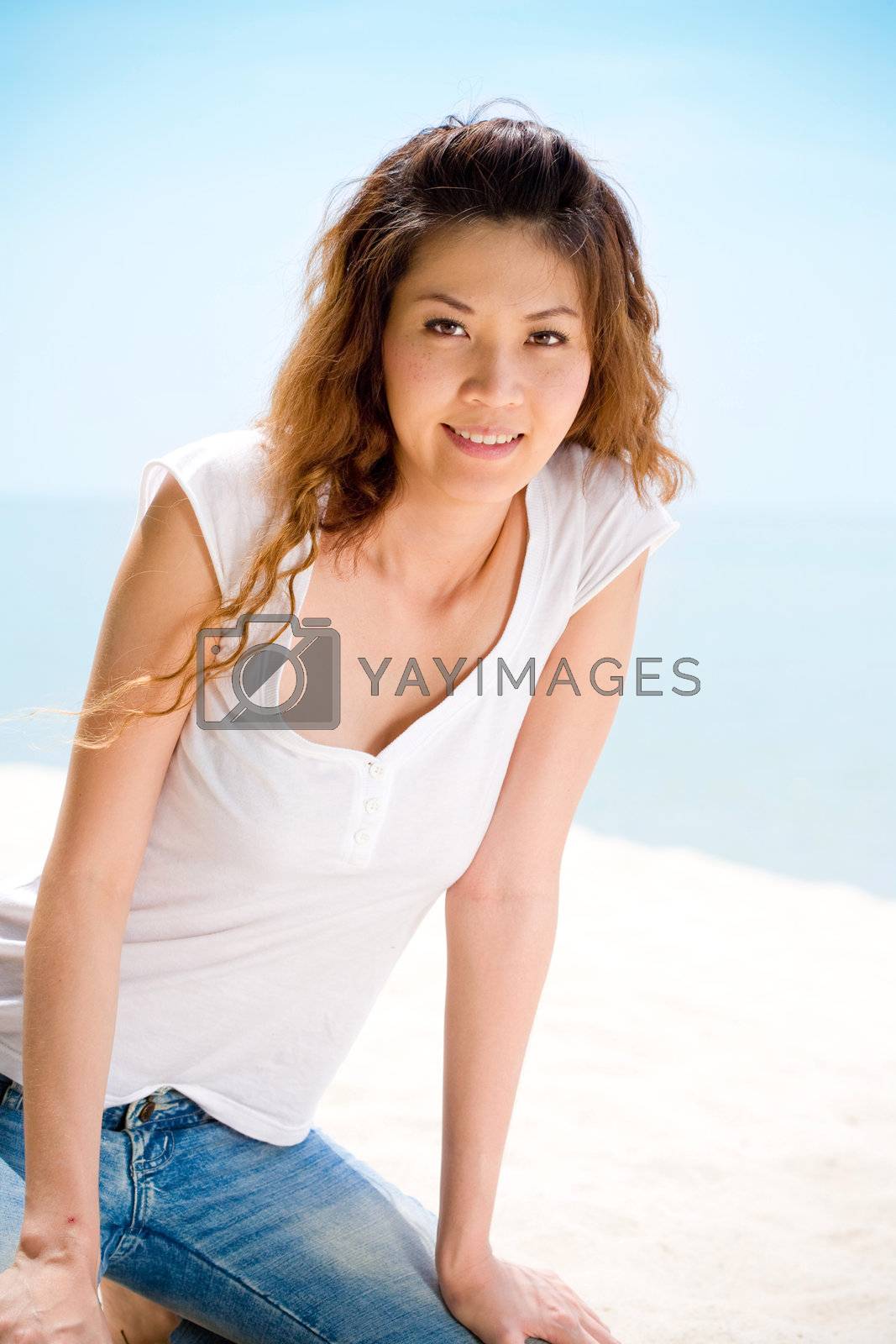 Royalty free image of happy woman sitting at the beach happily by eyedear
