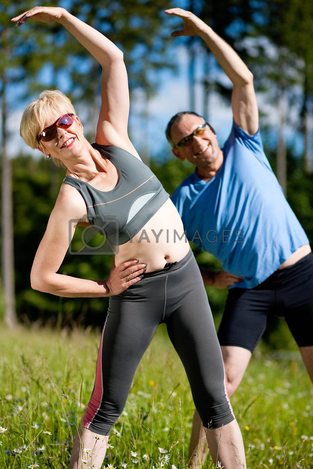Royalty free image of Senior couple doing sport exercising outdoors by Kzenon