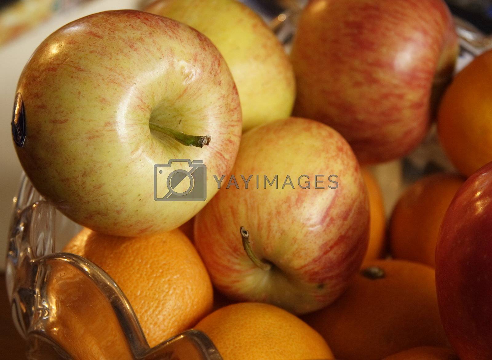 Royalty free image of fresh apples and oranges by leafy