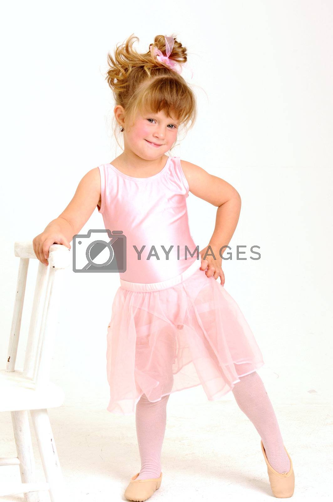 Royalty free image of Little young girl wearing pink ballet dress dancing and smile by Ansunette