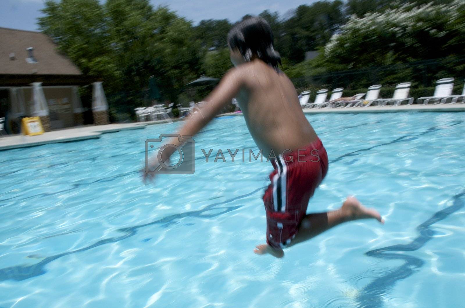 Royalty free image of Little boy jumping into pool by jedphoto