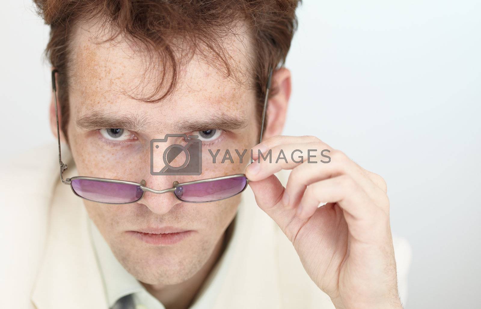 Royalty free image of Severe look of young man over spectacles by pzaxe