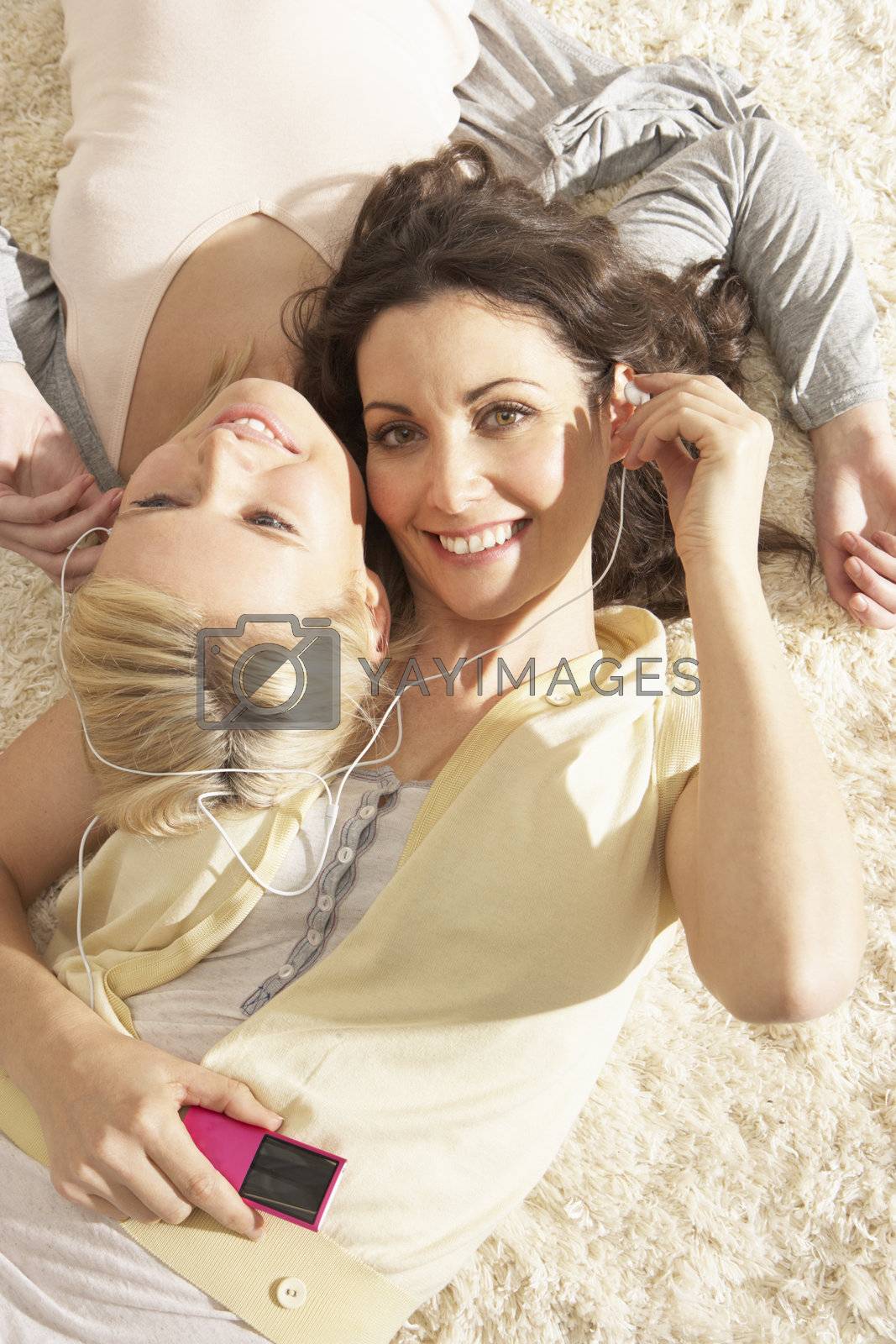 Royalty free image of Two Women Listening To MP3 Player On Headphones Together Relaxin by omg_images