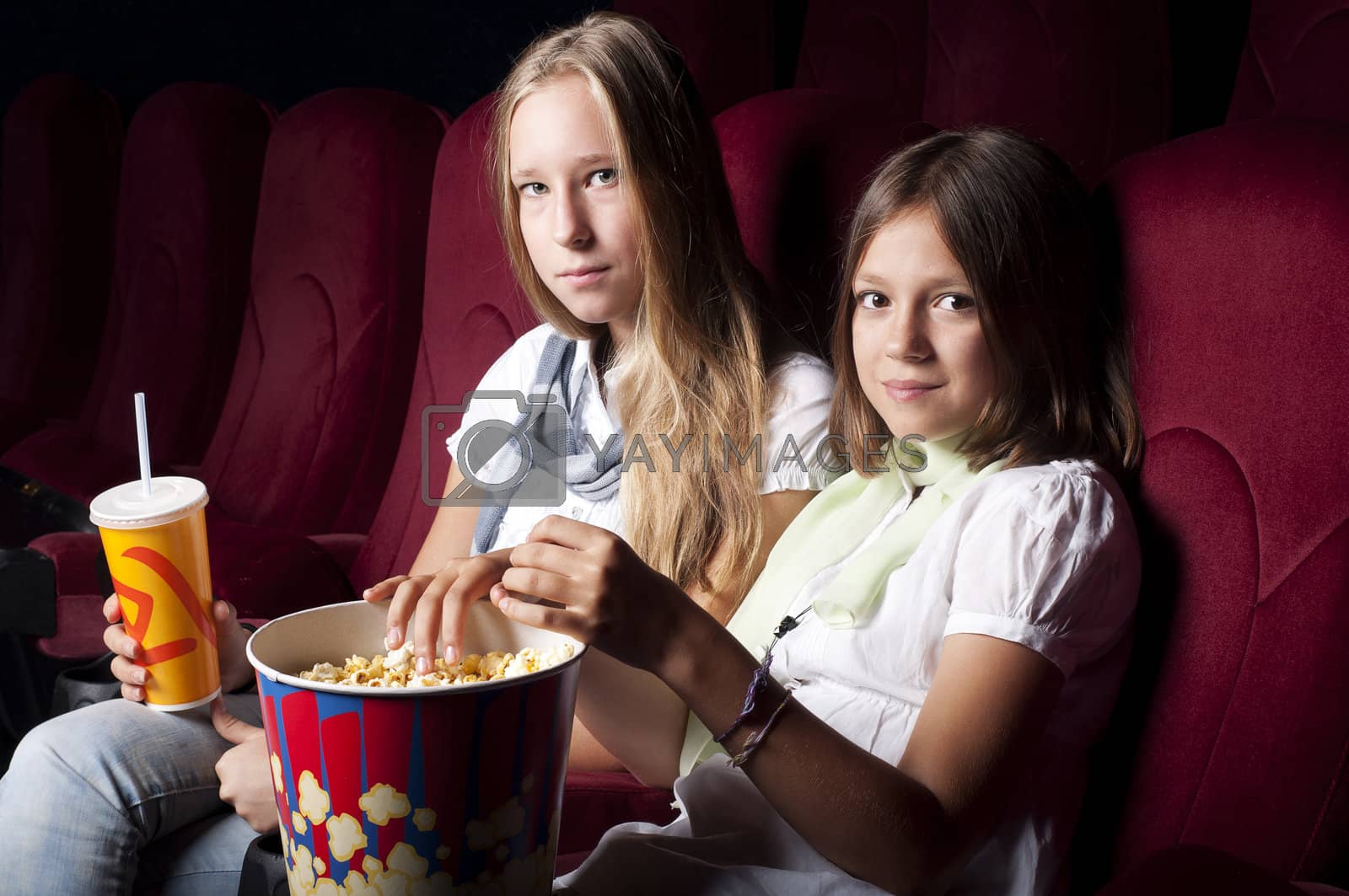 Royalty free image of two beautiful girls watching a movie at the cinema by adam121