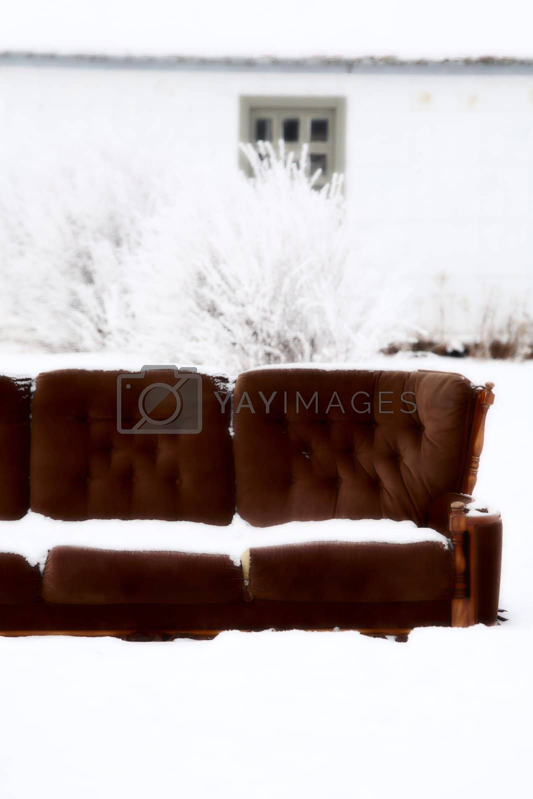 Royalty free image of Snow covered couch outside town house by pictureguy