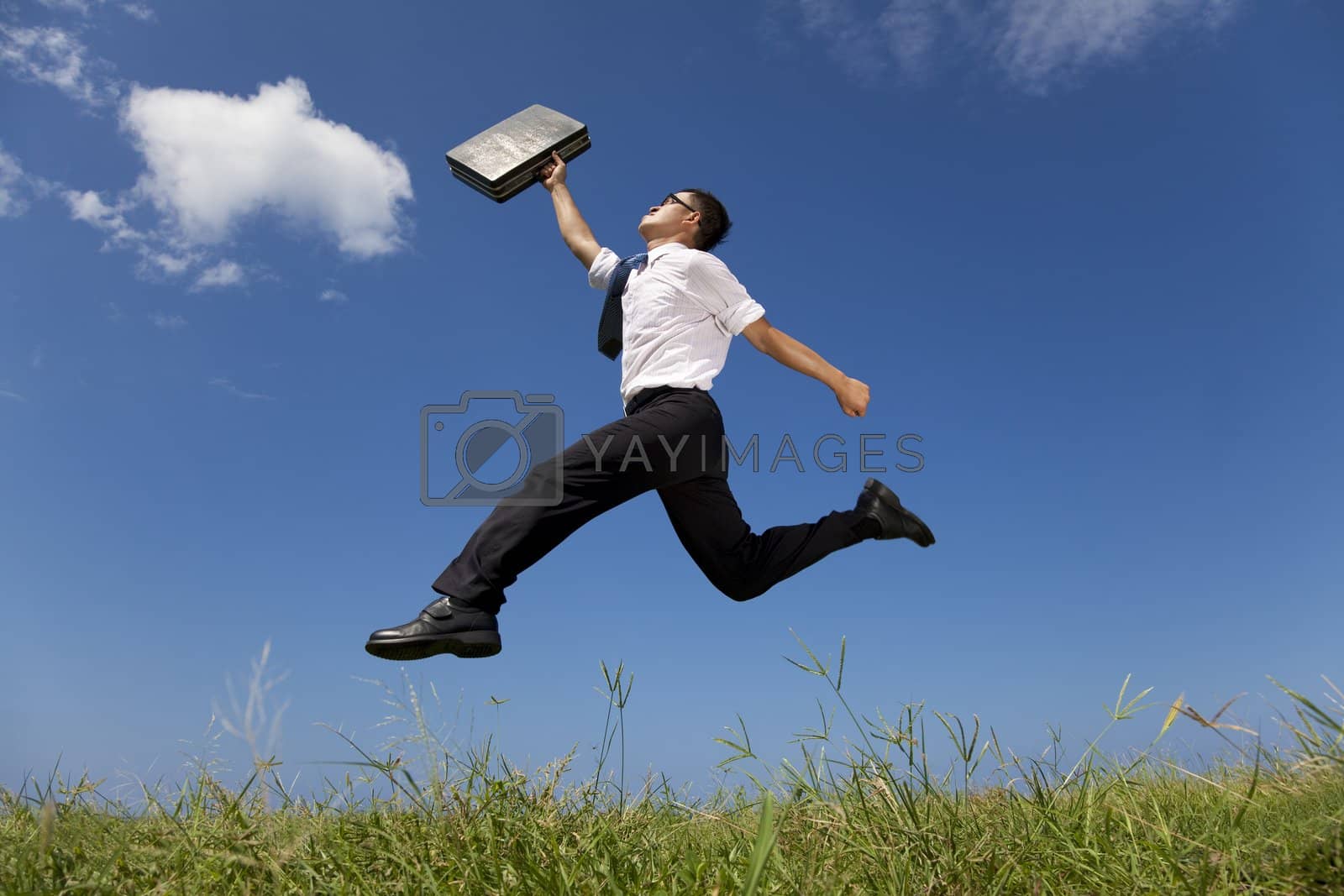 Royalty free image of happy businessman running over the grass field by tomwang