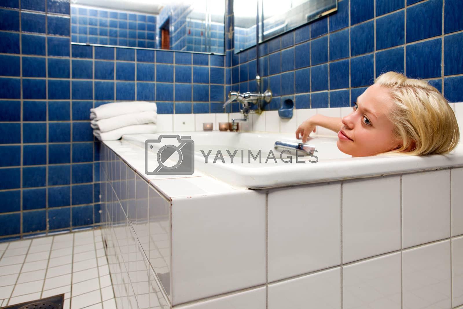 Royalty free image of Woman in Bathtub in Blue Room by leaf