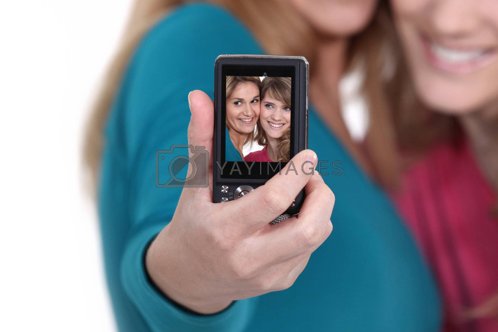 Royalty free image of Two friends taking a picture of themselves. by phovoir