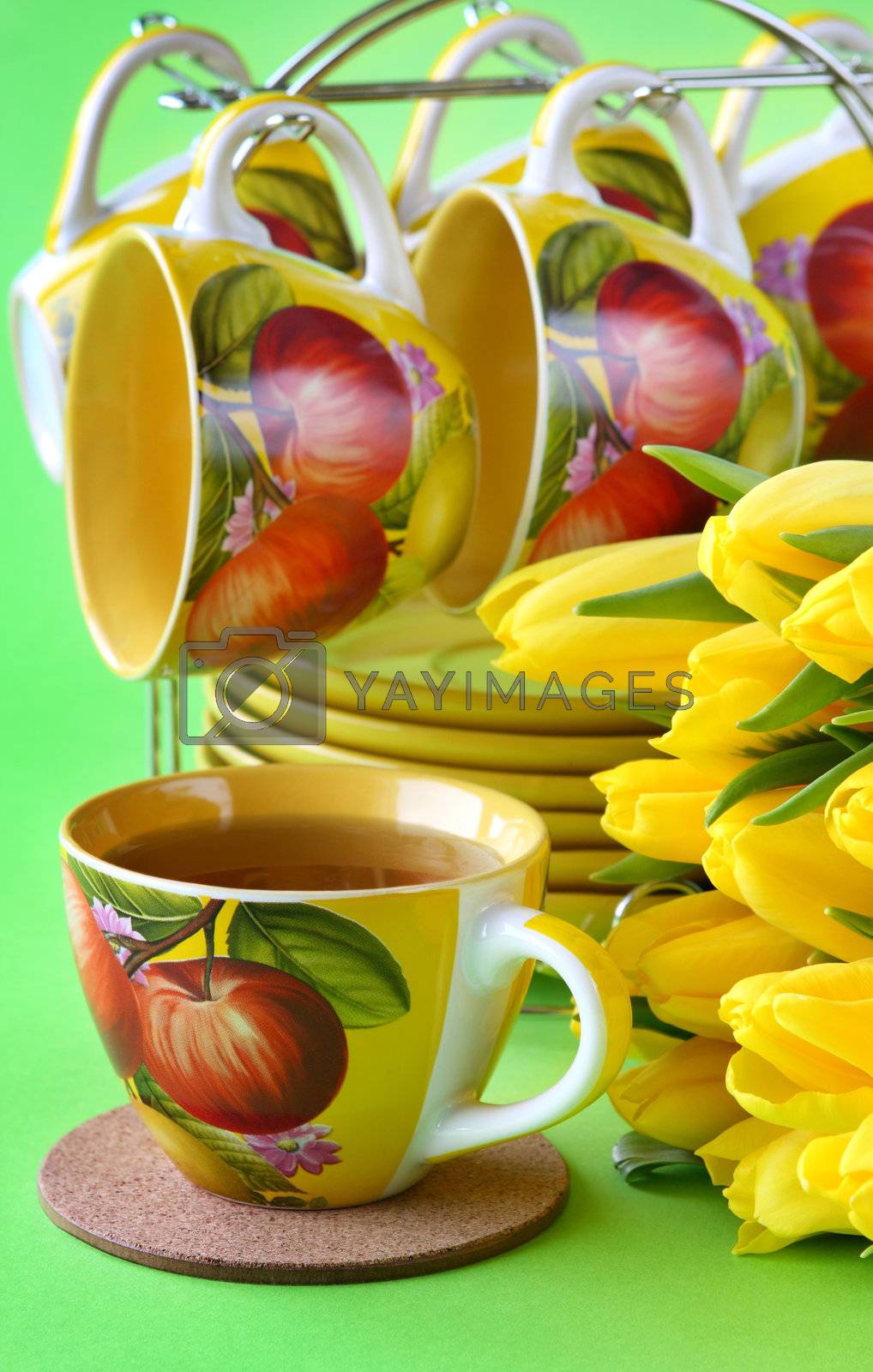 Royalty free image of Tea cups and yellow tulips by pozitivstudija