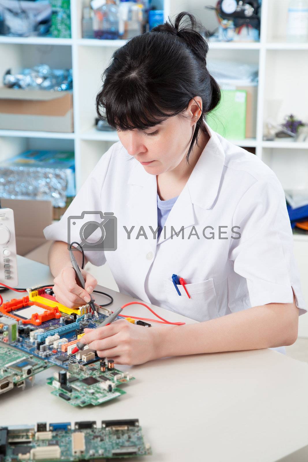 Royalty free image of Girl debugging an electronic precision device by motorolka