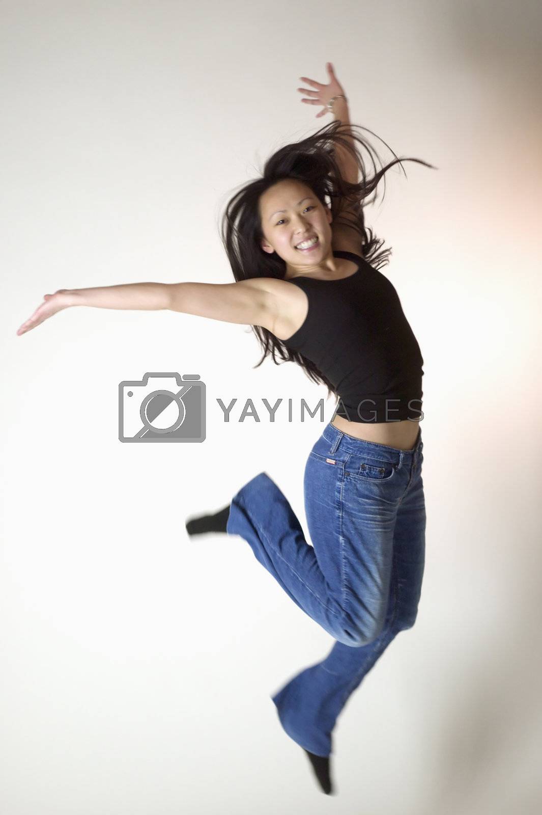 Royalty free image of Young Asian woman jumps for joy by edbockstock