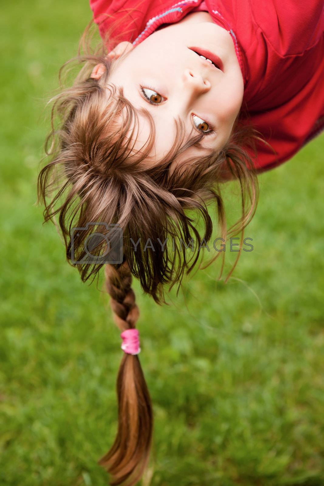 Caucasian girl hanging upside down in backyard - Stock 