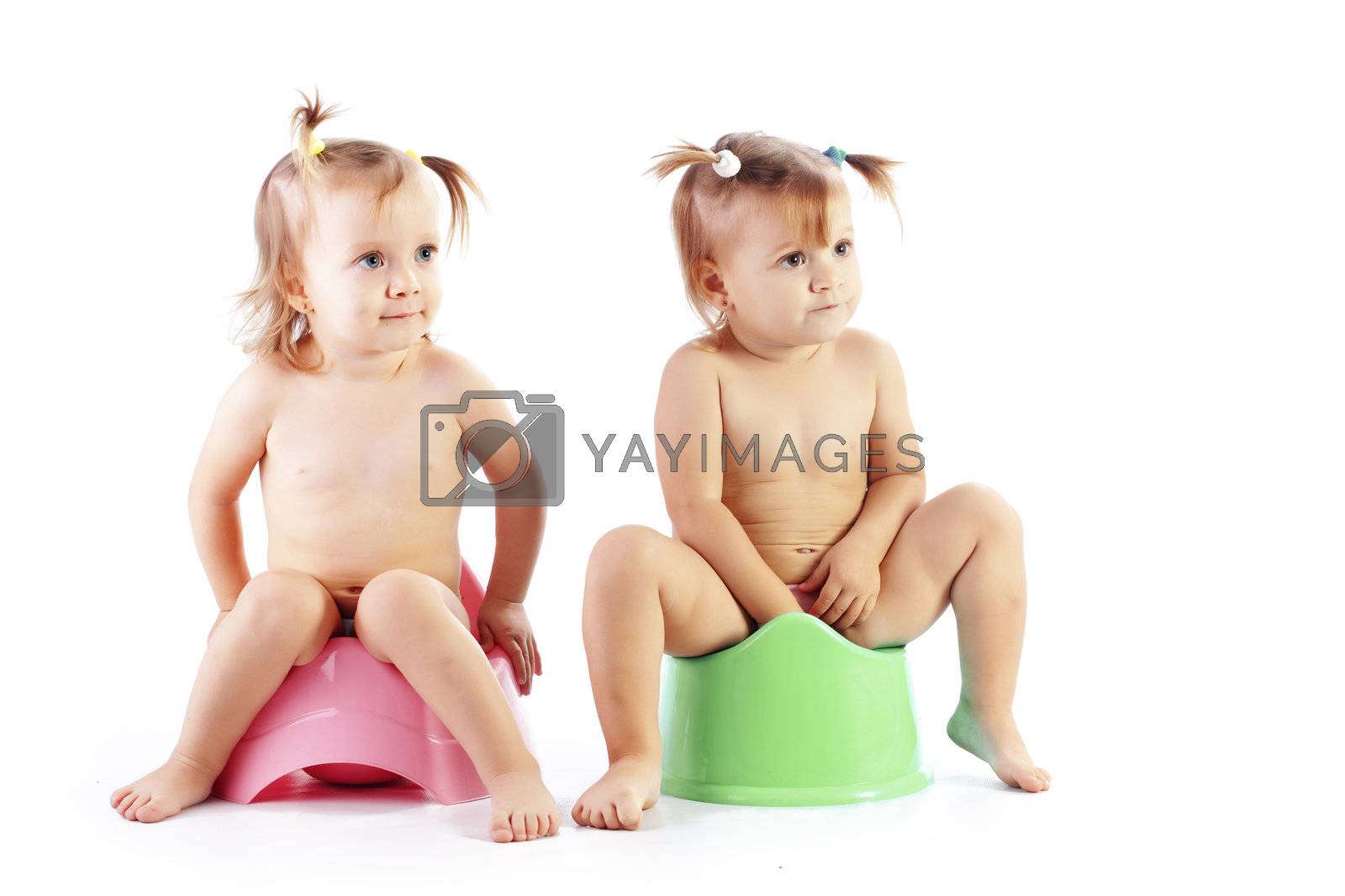 Studio shot of funny toddlers sitting on potty chairs