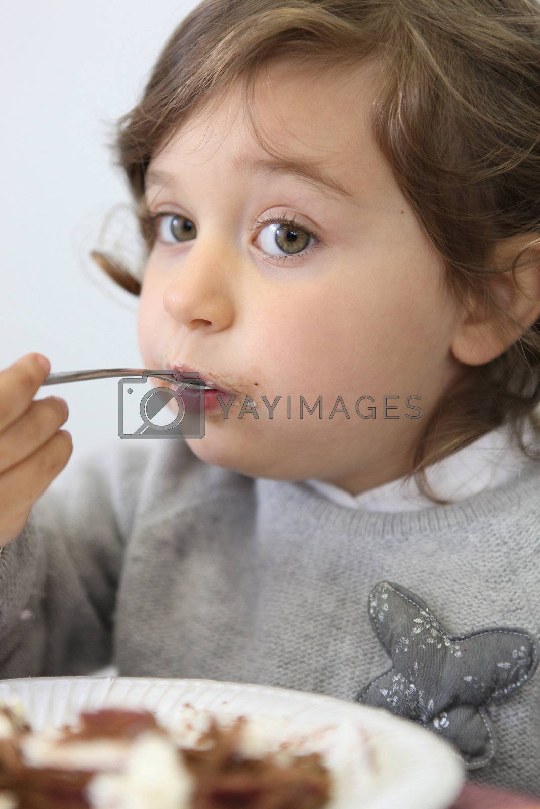 Royalty free image of Portrait of a little girl eating by phovoir