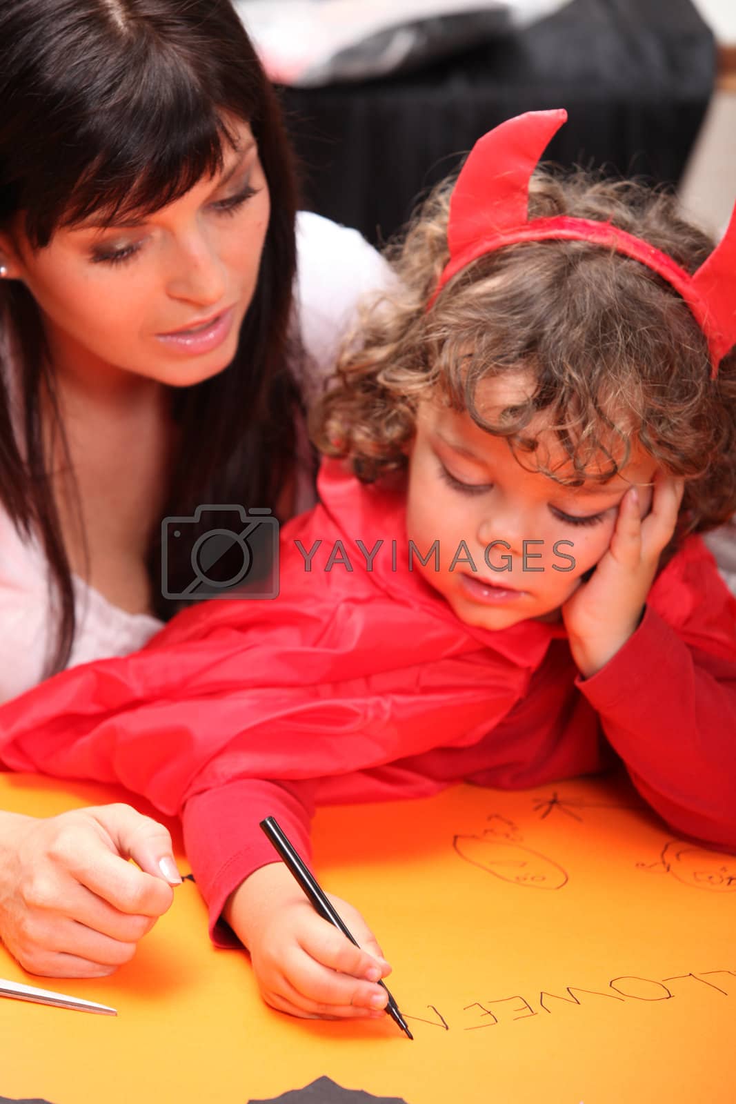 Royalty free image of A mother and her son getting ready for Halloween. by phovoir