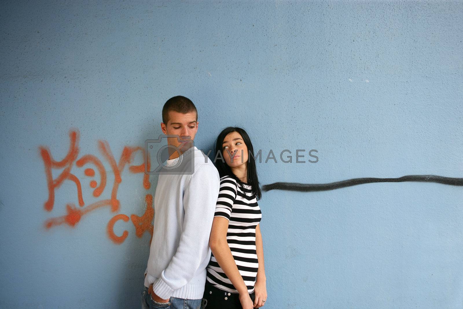 Royalty free image of Young couple stood by graffiti covered wall by phovoir
