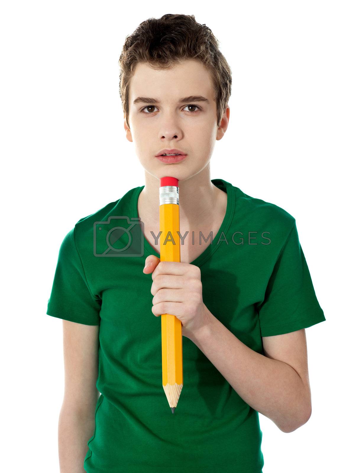 Royalty free image of School boy thinking while holding pencil by stockyimages