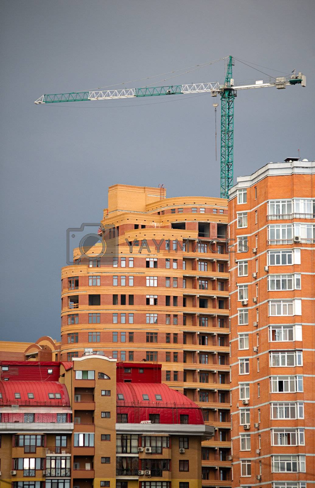 Royalty free image of Abstract of  multi apartments building and crane in a sunset by kirs-ua