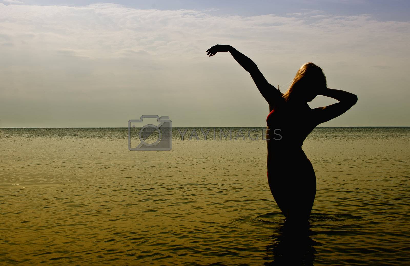 Royalty free image of Silhouette of woman in the sea by dmitrimaruta