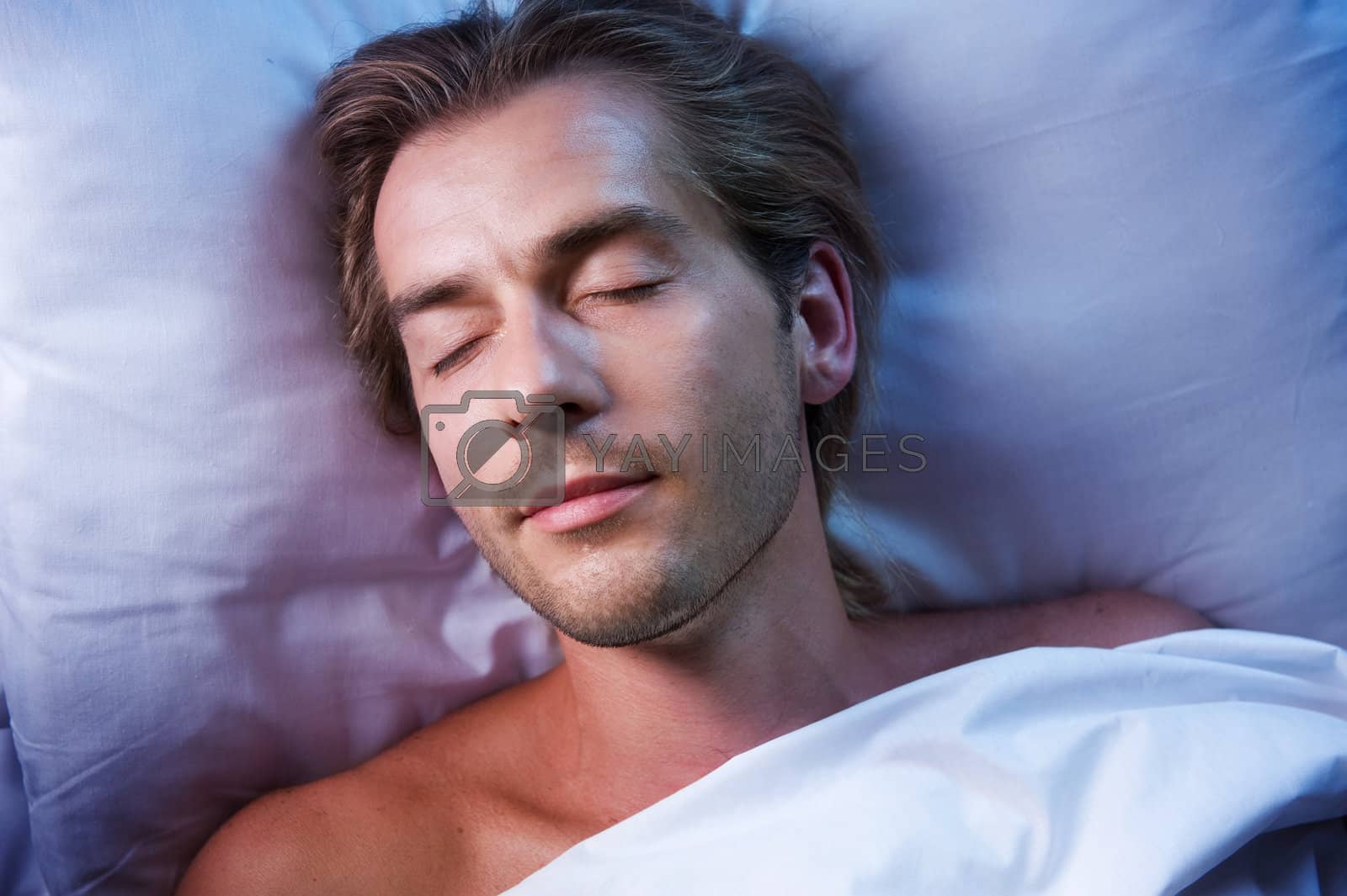 Royalty free image of Young Man Sleeping In His Bed by SubbotinaA