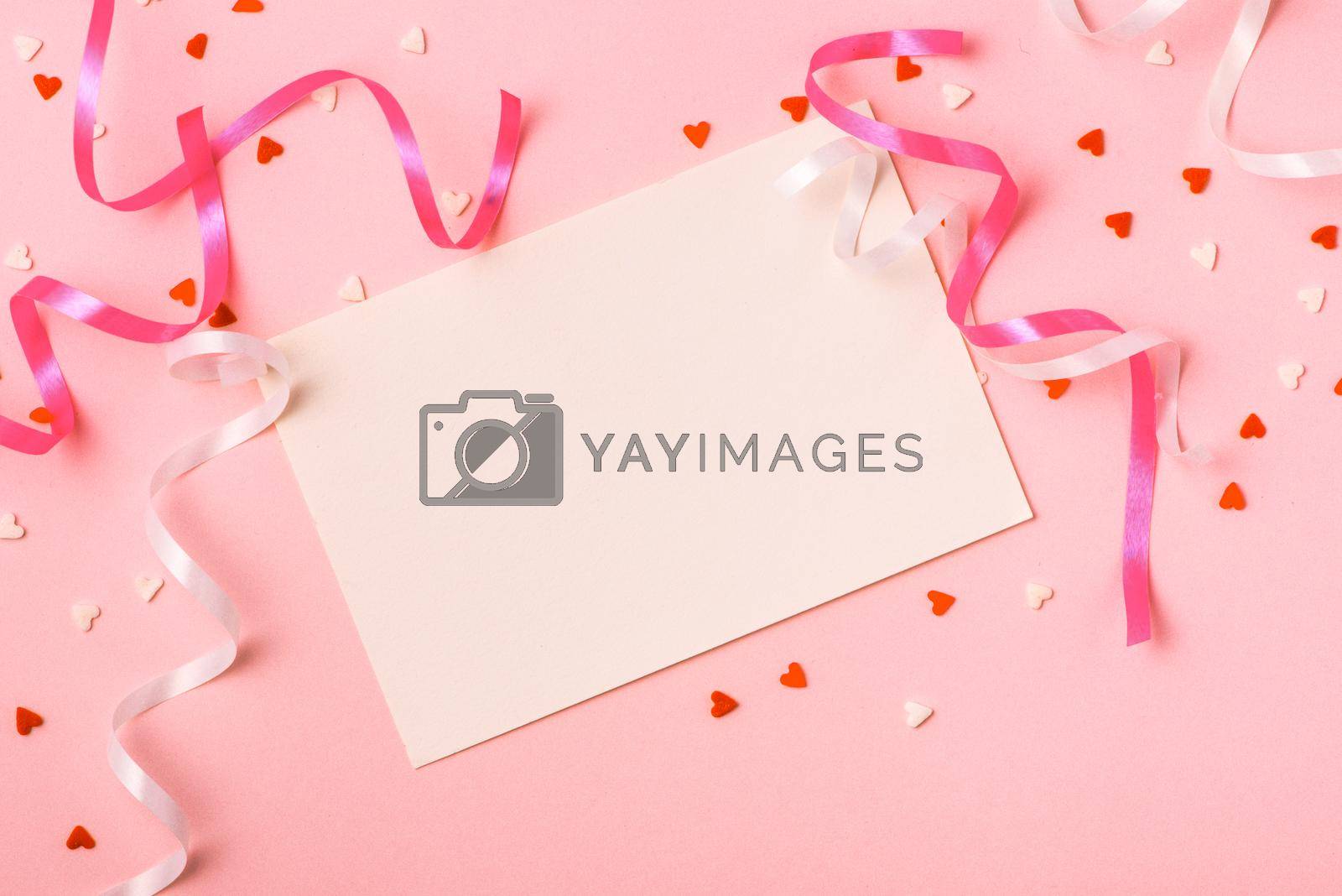 Royalty free image of Delicate pink party background with streamers for celebrating with scattered confetti by makidotvn
