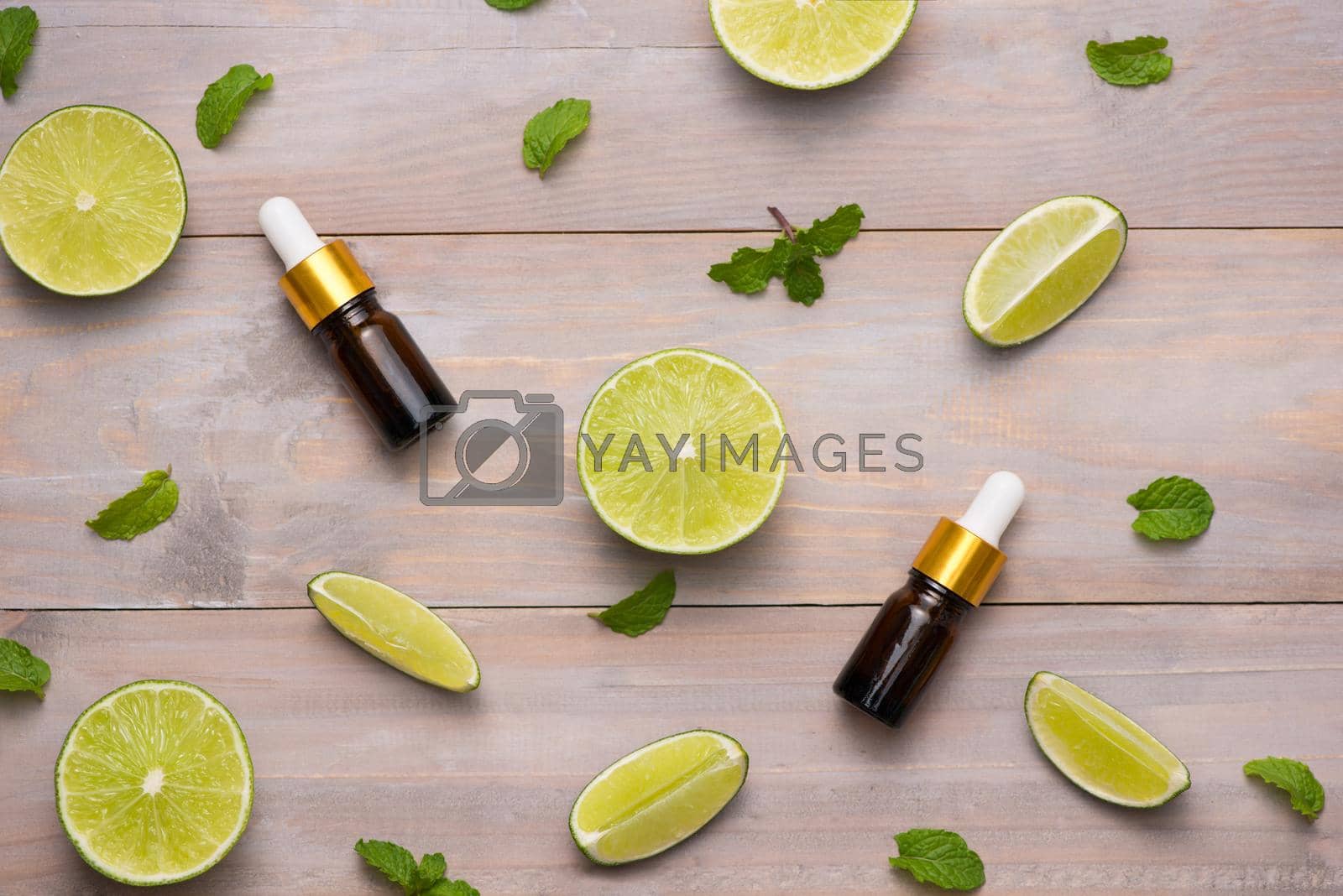 Royalty free image of Natural cosmetics for home spa. Bottle of essence oil with fresh limes  by makidotvn