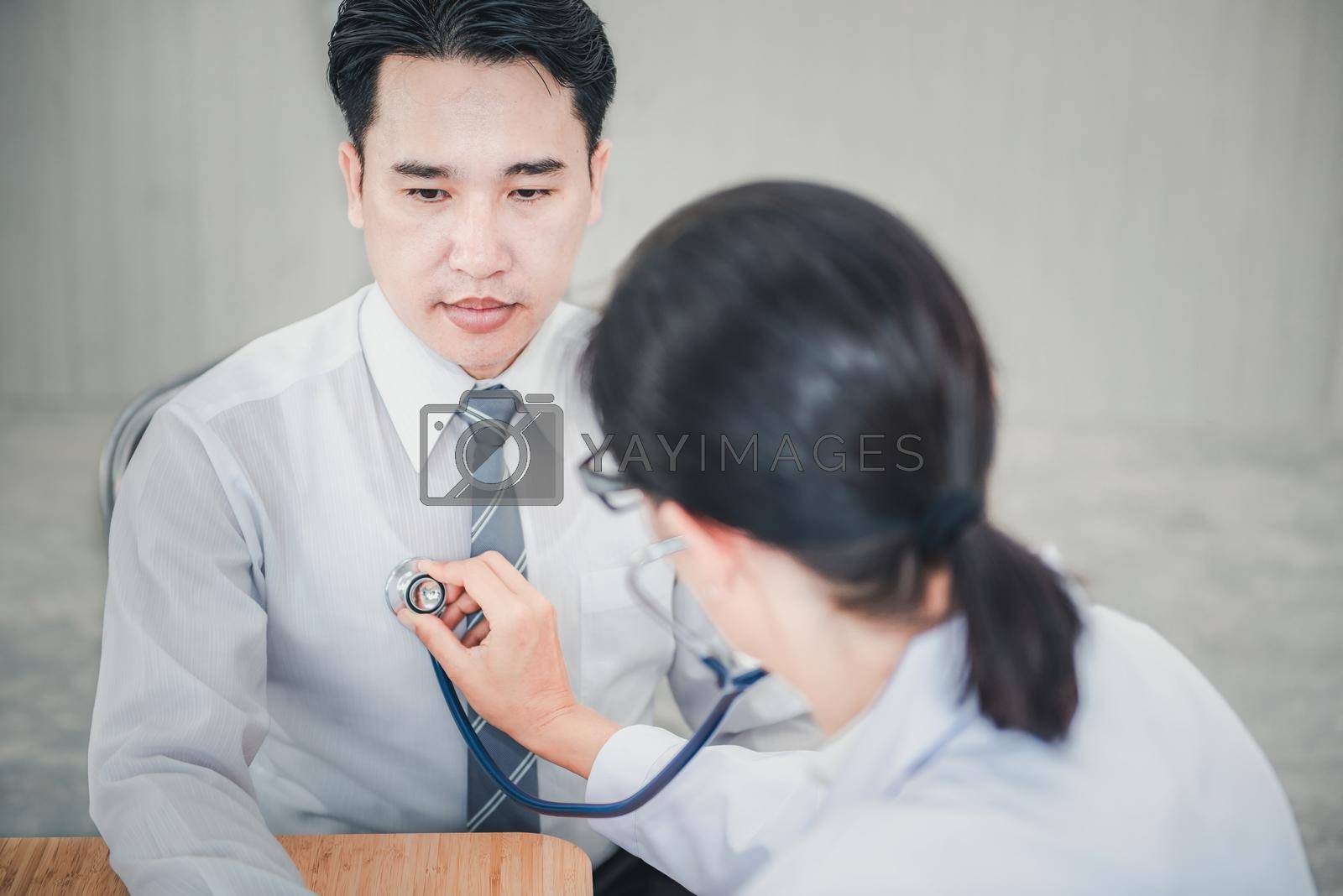Royalty free image of Medical Doctor is Examining Patient Health With Stethoscope in Hospital Examination Room, Female Physician Doctor is Diagnosing Physical Health Check Up for Male Patient. Medicine/Healthcare Concept by MahaHeang245789