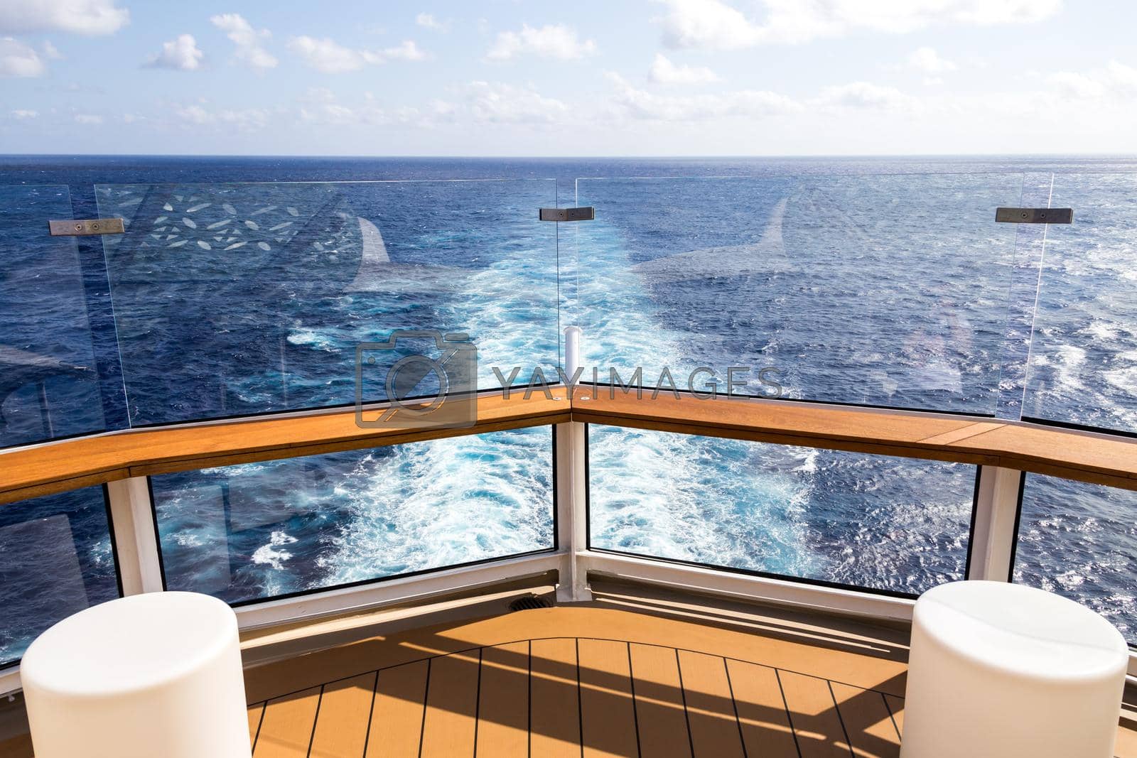 Deck of cruise ship with wake or trail on ocean surface, white trace