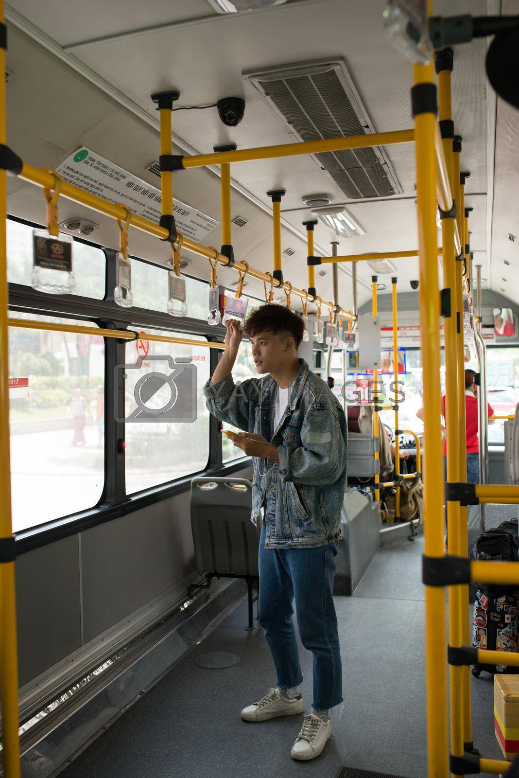 Royalty free image of People in the bus. Asian man using smartphone in public transport by makidotvn