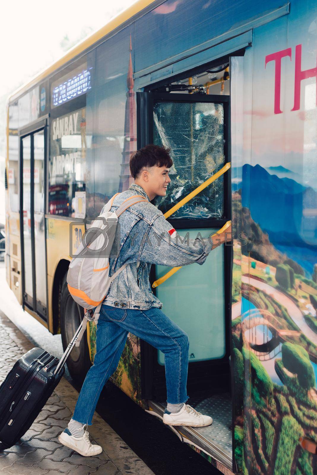 Asian male young traveler getting on the tourist bus for travel