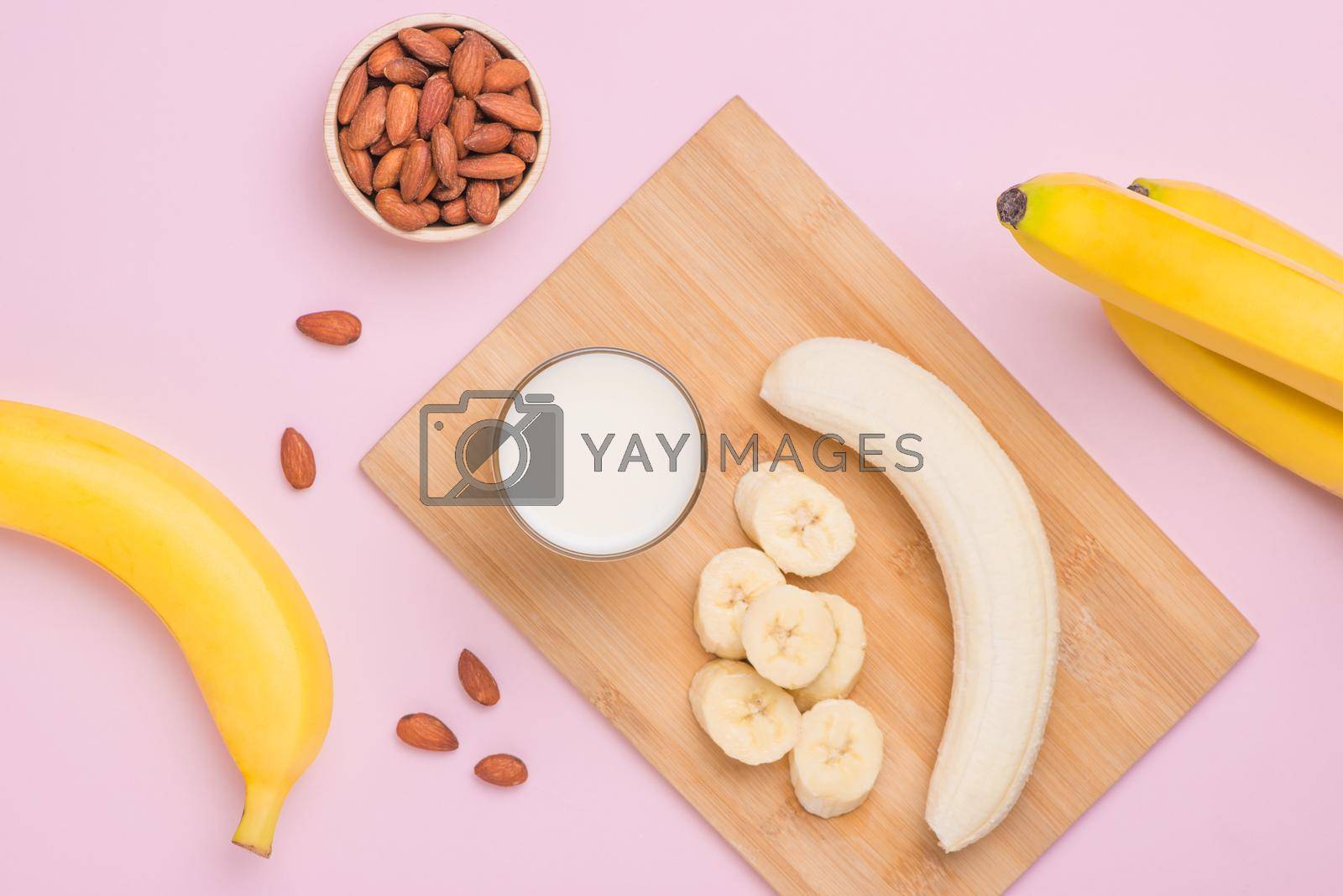 Royalty free image of Bananas with almonds and milk on pink background. by makidotvn