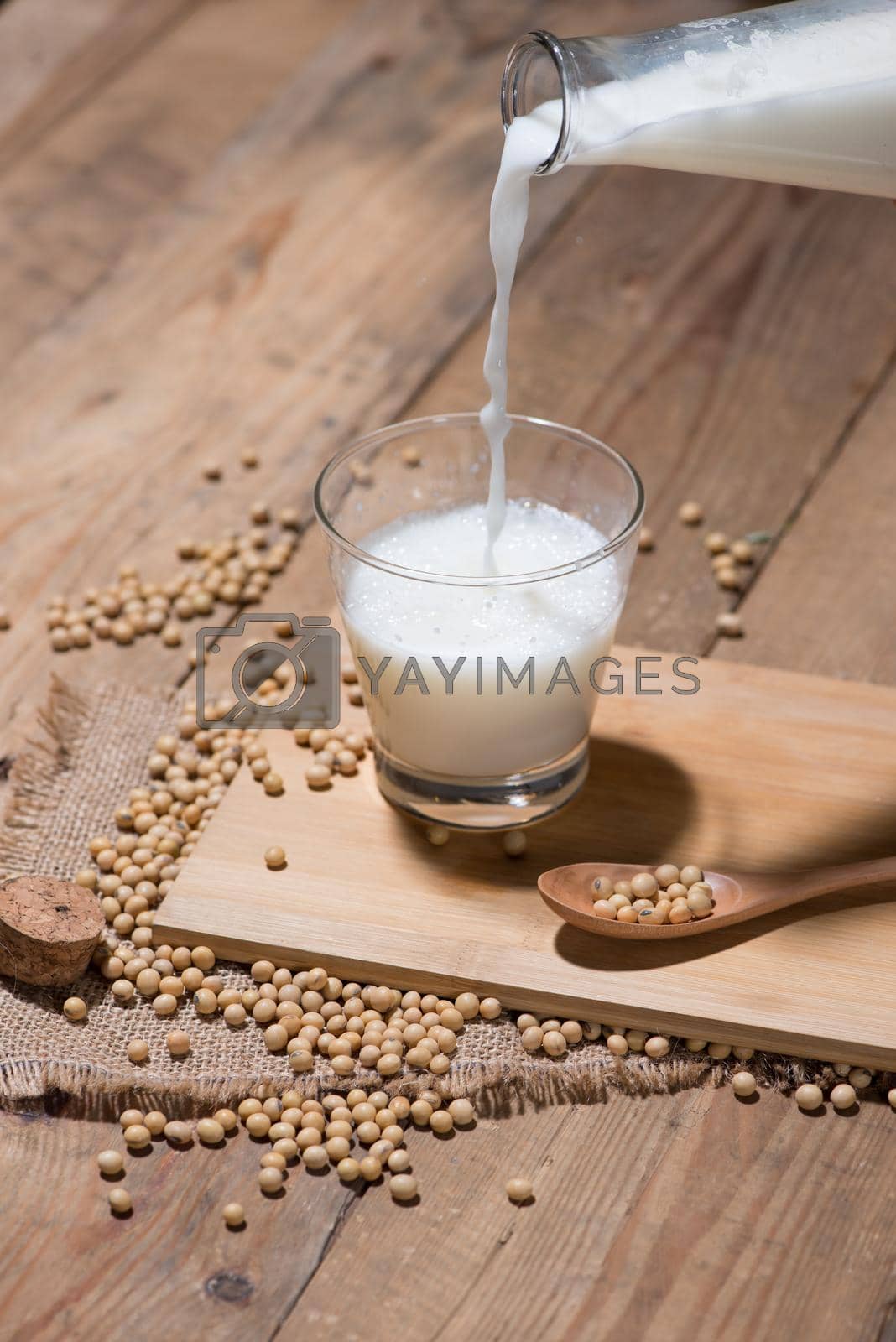 Royalty free image of Soy milk or soya milk and soy beans in spoon on wooden table.  by makidotvn