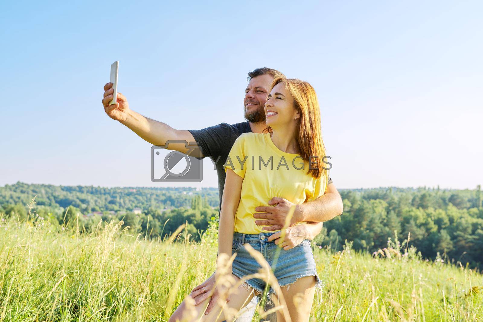 Royalty free image of Beautiful happy adult couple taking selfie on smartphone by VH-studio