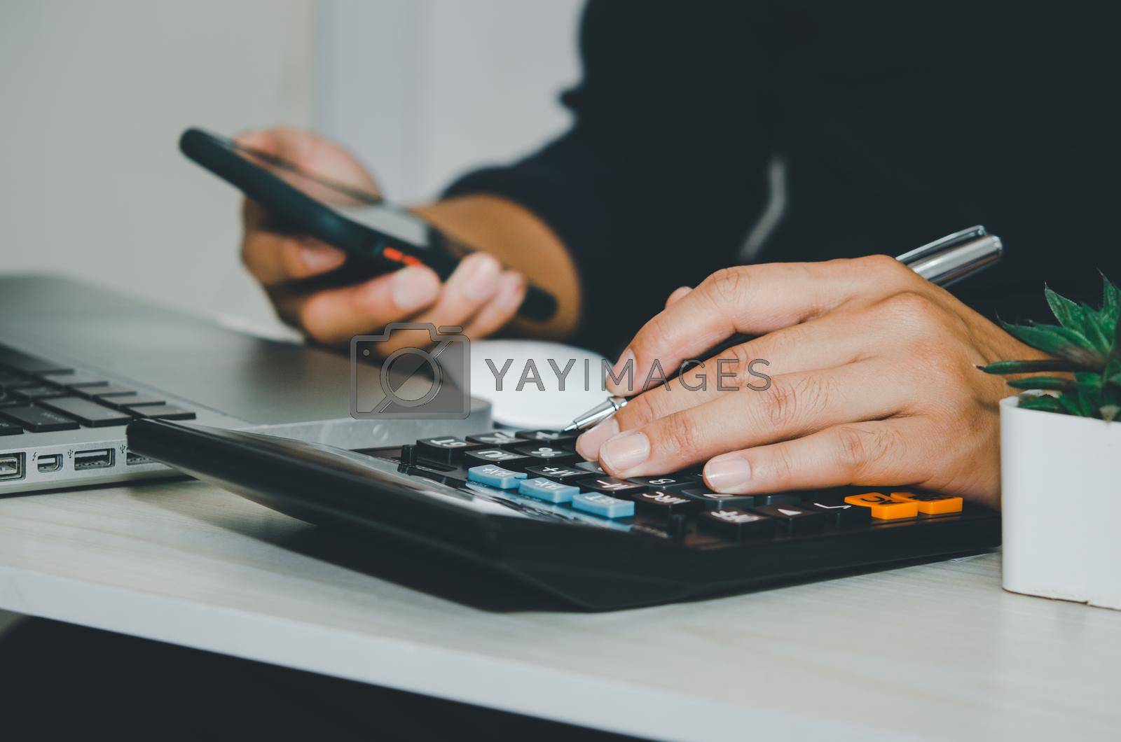businessman using a calculator business tax financial or marketing business online.